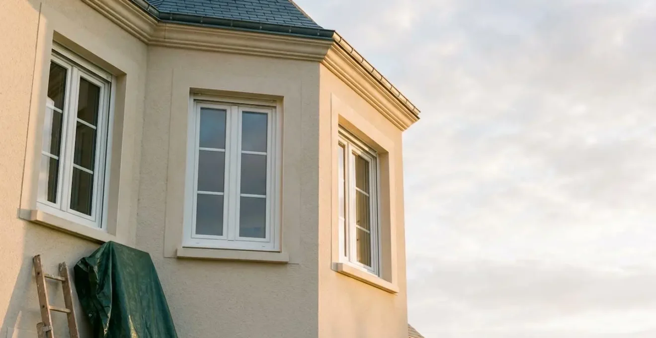 Façade d'une maison française rénovée avec de larges fenêtres en PVC blanc, symbole d'une rénovation énergétique réussie