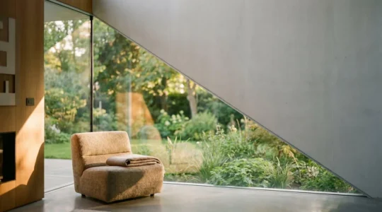 Grande baie vitrée d'angle minimaliste ouvrant un salon contemporain sur un jardin verdoyant, sans profilé apparent